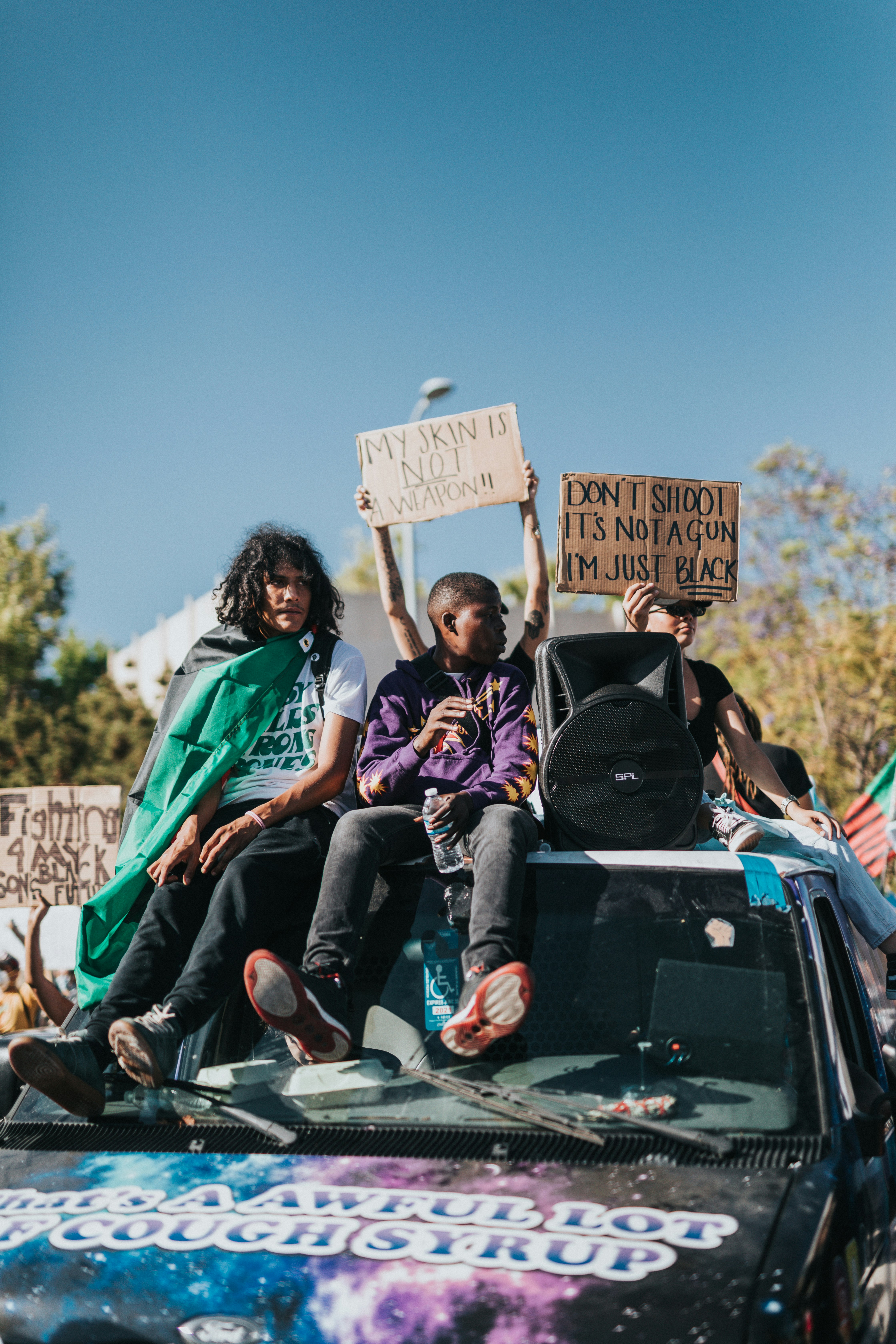 man and woman sitting on car roof during daytime